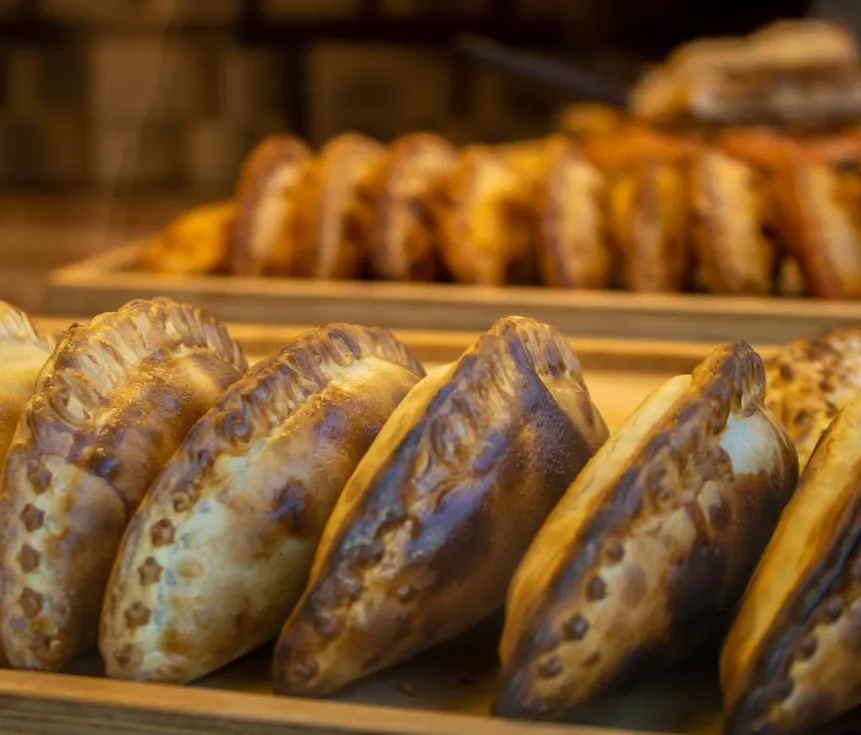 Variedad de empanadas horneadas sobre bandejas de madera